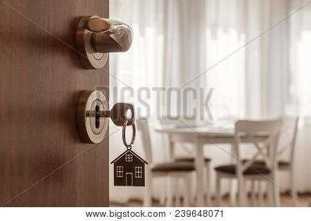 Open Door To A New Home. Door Handle With Key And Home Shaped Keychain. Mortgage, Investment, Real E