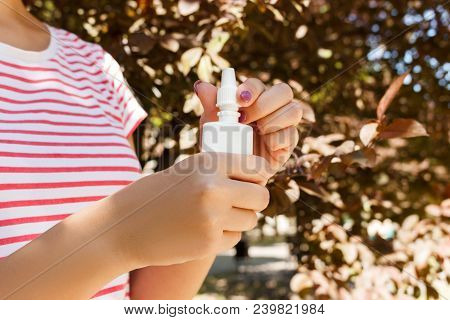 Nasal Drops Bottle, Female Hand Spraying Nasal Spray With Blurred Background