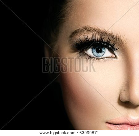 Beauty makeup for blue eyes. Part of beautiful face closeup. Perfect skin, long eyelashes. Make up concept. isolated on black background