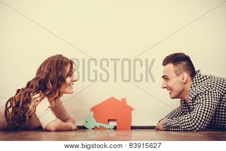 Couple Lying On Floor Daydreaming At Home