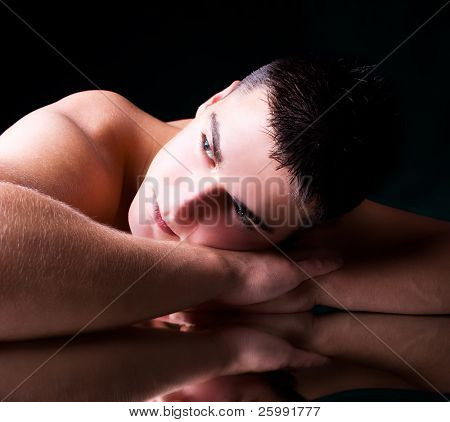 muscular young man lying on his hands, studio shot