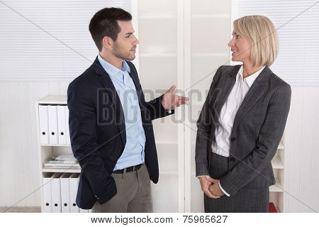 Business people in suit and dress talking together: small talk.