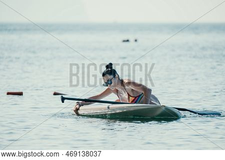 Sea Woman Sup. Silhouette Of Happy Middle Aged Tanned Woman In Rainbow Bikini, Surfing On Sup Board,