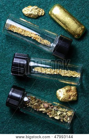 Flaschen mit Goldstaub und Gold-Nuggets