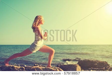 Young Woman Doing Yoga On  Beach