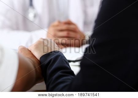 Young Couple Hold Hands Together In Doctor Office Closeup