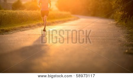 Male athlete/runner running on road - jog workout well-being concept