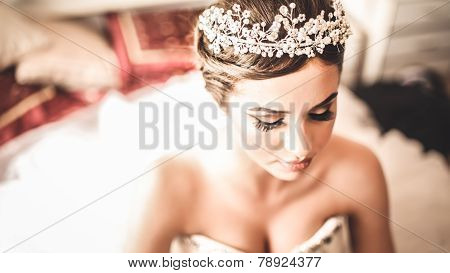 Gorgeous bride portrait in her wedding dress wearing tiara. Beautiful bridal makeup and hairstyle