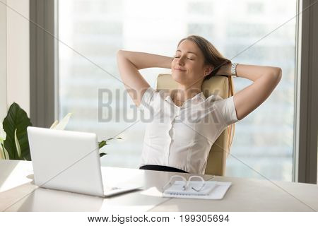 Calm smiling businesswoman relaxing at comfortable office chair hands behind head, happy woman resting in office satisfied after work done, enjoying break with eyes closed, peace of mind, no stress