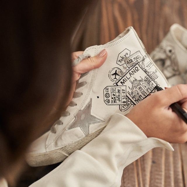 person-drawing-on-a-white-leather-sneaker