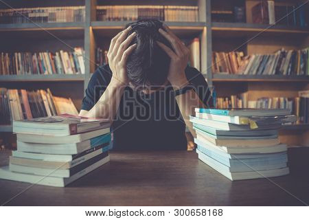 Stress And Tired Man Under Mental Pressure While Reading Book Preparing Examination In Library. 
Bus