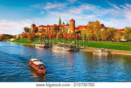 Wawel castle famous landmark in Krakow Poland. Picturesque landscape on coast river Wisla. Autumn sunset with white sky and cloud.