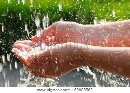 Hands catching clean falling water close up. Environmental concept.