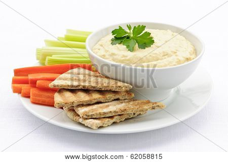 Healthy snack of hummus dip with pita bread slices and vegetables