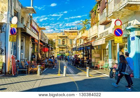 TEL AVIV ISRAEL - FEBRUARY 25 2016: The shady street of old Jaffa hides the cozy outdoor cafes and shops of retro furniture so popular in the local flea market on February 25 in Tel Aviv.