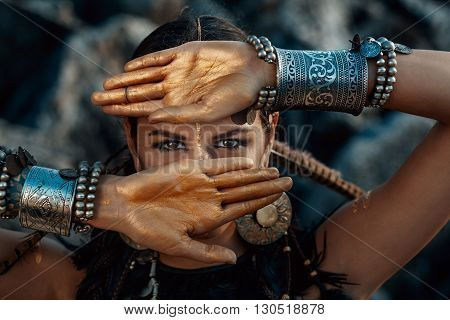 Attractive tribal woman posing in ethnic jewelry outdoors