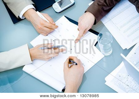 Close-up of hands of teamworking businesspeople on meeting at office.