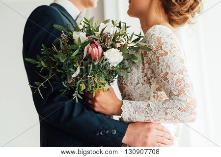 Bride And Groom Together Holding Wedding Bouquet