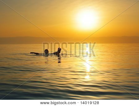 Woman swimming in salty water of a Dead Sea