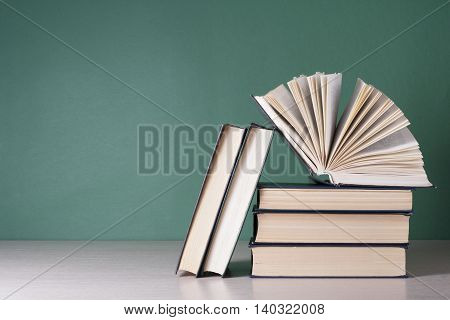 Open book, hardback books on wooden table. Education background. Back to school. Copy space for text