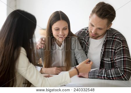 Millennial Couple Considering Mortgage Investment Loan, Planning Wedding At Meeting With Financial A