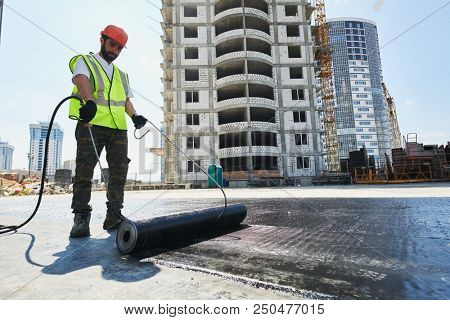 Flat roof construction and insulation. Heating and melting bitumen roofing felt