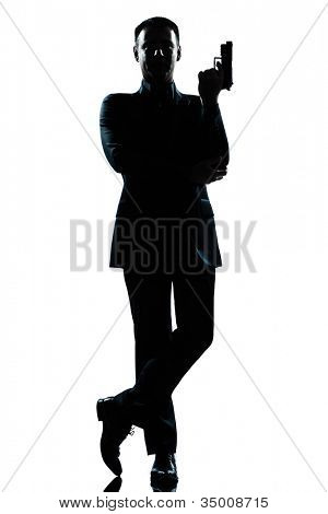 one caucasian secret agent in a james bond posture holding gun full length silhouette in studio isolated white background