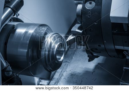 The Cnc Lathe Machine In Metal Working Process Cutting The Metal Ring Parts With In The Light Blue S