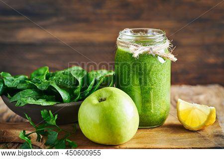 Fresh healthy green spinach and apple smoothie served in jar with lemon for diet and detox.Smoothie fruit detox breakfast. Green smoothie detox diet. Diet fruit and vegetable smoothie. Green Smoothie. Green detox diet smoothie. Green vegie smoothie detox.