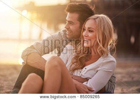 two lovers at santa monica beach holding each other with lens flare and warm image tone