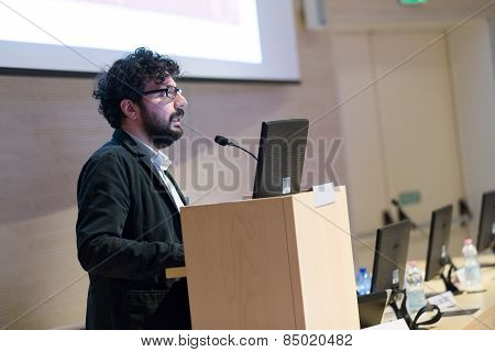 Speaker giving talk on podium at Business Conference.