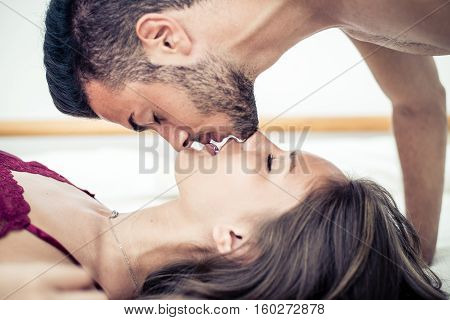 Couple kissing in bed. Romantic passion and love in bed