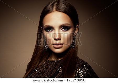 Glamour portrait of beautiful girl model with makeup and romantic hairstyle. Fashion shiny highlighter on skin, sexy gloss lips make-up and dark eyebrows.