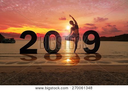 Greeting Card 2019 Happy New Years. Silhouette Of Healthy Young Woman Practicing Yoga On Tropical Be