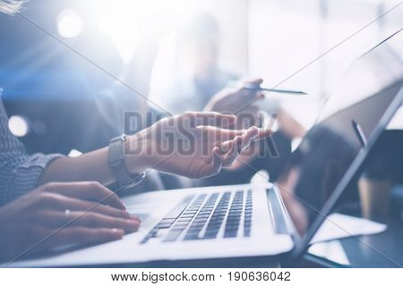 Business meeting concept.Closeup view of business people working with mobile computer at modern office.Analyze business plans, using laptop.Blurred background.Cropped