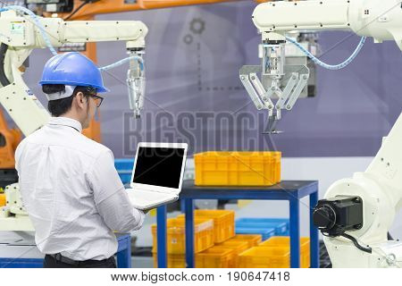 The mechanical engineer control robot arm in manufacturing factory. Industrial 4.0 concept.Modern technology for manufacturing