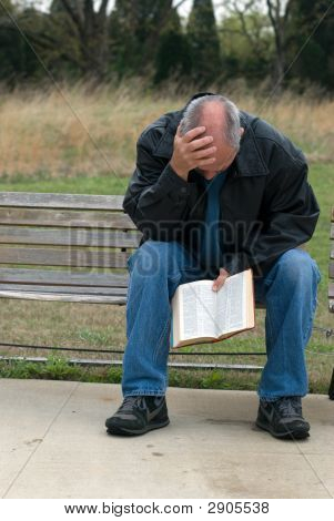 Sad Man Holding Bible