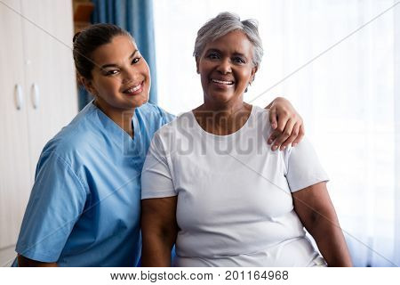 Portrait of young nurse with senior patient in nursing home