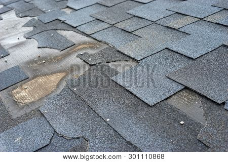 Сlose Up View Of Bitumen Shingles Roof Damage That Needs Repair.