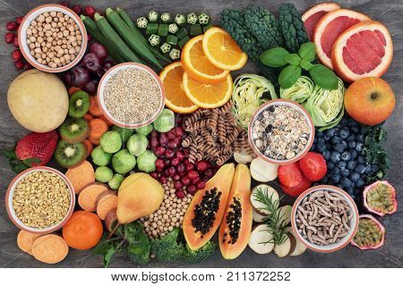 Health food concept for a high fiber diet with fruit, vegetables, cereals, whole wheat pasta, grains, legumes and herbs. Foods high in anthocyanins, antioxidants, smart carbohydrates and vitamins. 