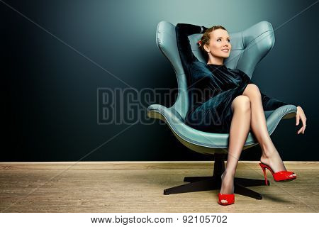 Portrait of a stunning fashionable model sitting in a chair in Art Nouveau style. Business, elegant businesswoman. Interior, furniture.