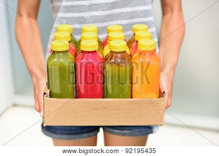 Juicing cold pressed vegetable juices for a detox diet. Dieting by cleansing your body from toxins with raw organic fruits and vegetables juice made fresh and delivered in bottles.