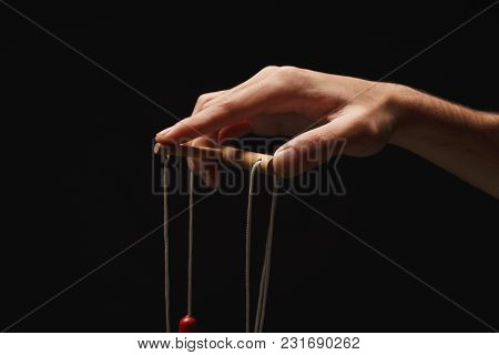 Male Hand With Marionette Strings On Black Isolated Backgorund. Manipulation, Control And Dictatorsh