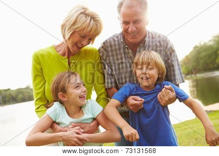 Grandparents Playing With Grandchildren Outdoors