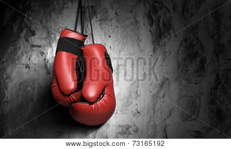 Pair of red boxing gloves hanging on wall