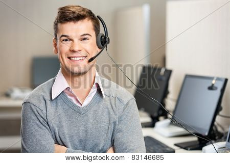 Portrait of confident male customer service representative with headset in call center