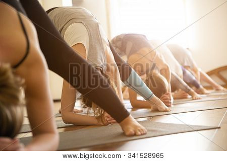 Yoga Class, Group Of People Relaxing And Doing Yoga Pose. Wellness And Healthy Lifestyle.