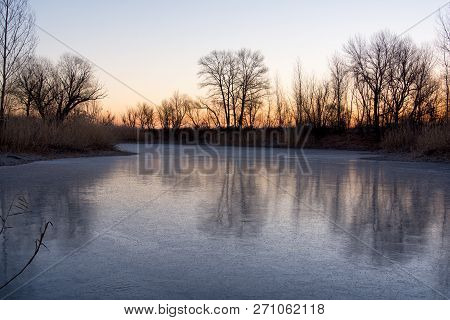 Beautiful Landscape Of Forest Lake In The Early Morning. Frozen Lake In The Forest. The Reflection O