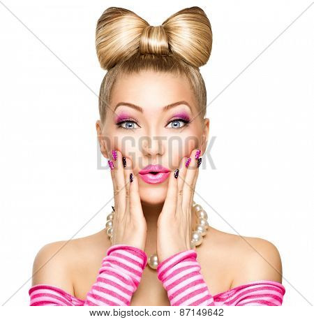 Beauty surprised fashion model girl with funny bow hairstyle, pink nail art and makeup isolated over white background. Expressing positive emotions, smile. Beautiful young woman portrait