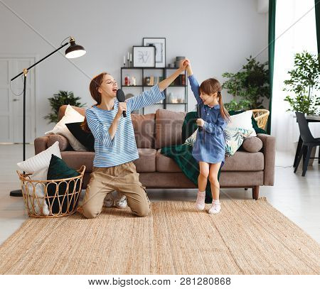 Happy Family Mother And Child Daughter Play At Home And Sing With Combs